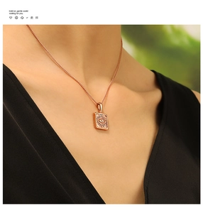 Detail of rose gold rectangular pendant with evil eye engraving and zircon stone