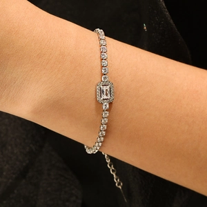 Elegant silver tennis bracelet with emerald cut center stone and sparkling cubic zirconia stones