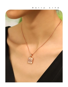 Close-up of gold evil eye square pendant necklace worn by a model on a lifestyle background