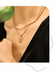 Detail of double-layer gold PVD coated necklace with evil eye rectangular pendant for women