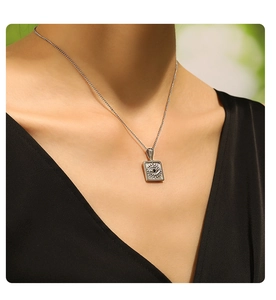 Detailed close-up of an Evil Eye square pendant necklace worn by a female model