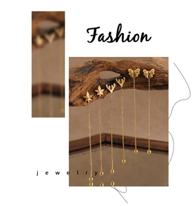 Detailed view of elegant gold-plated tassel earrings with butterfly and star leaf designs