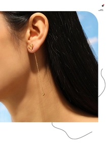 Detailed view of gold plated V-shaped tassel threader earrings worn by a model