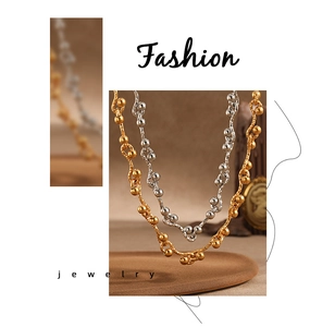 Close-up of gold and silver chunky necklaces with wavy link texture and metal beads