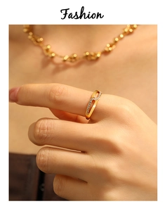Nahaufnahme eines doppellagigen Gold-Wellenrings mit Zirkonia am Finger einer Frau