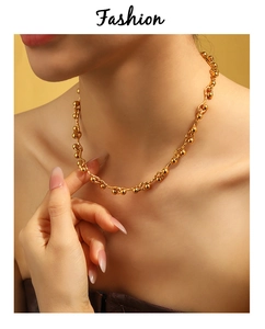 Detail of PVD gold plated chunky chain necklace with spherical beads on model neck