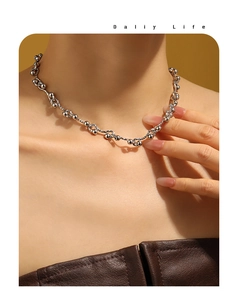 Detailed view of silver metal chunky beaded chain necklace worn by a model
