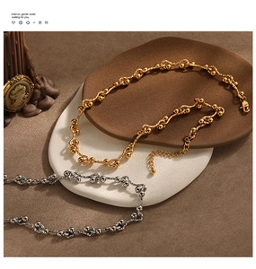 Detail of gold and silver chunky chain necklaces with knot design and lobster clasp