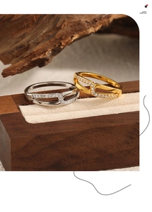 Nahaufnahme von silbernen und goldenen X-Ringen mit Zirkonia-Besatz auf Holzständern