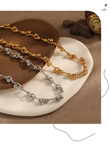 Detailed macro view of gold and silver chunky wave chain necklaces with bead accents