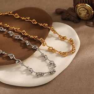 Minimalist PVD gold and silver chunky chain necklaces with knot design on vintage background