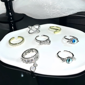 Minimalist evil eye and zircon open rings set featuring cross and wave designs on white tray