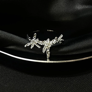 Detail of silver moonstone ring with sparkling star charms on black silk fabric