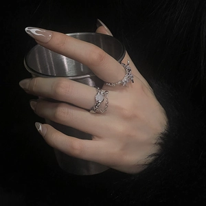 Detail of silver moonstone rings set featuring lava texture and metallic chain accents