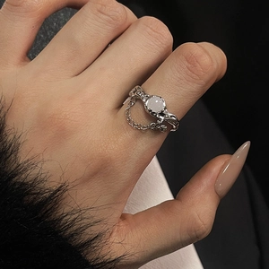 Detail of moonstone ring with irregular liquid metal texture and hanging chain detail