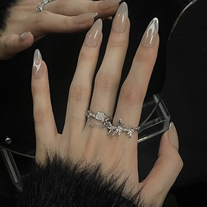 Detail of silver Gothic rings with tassel chain, white stone and thorn design
