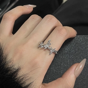 Detailed view of silver thorn design rings with micro-inlaid stones on model finger