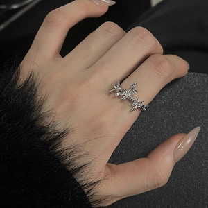 Detail of silver irregular lava texture ring featuring triple star design on hand