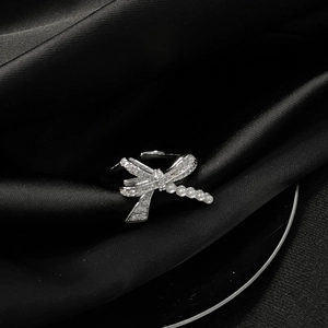 Makro-Detail des silbernen Libellenrings mit Zirkonia-Flügeln und Perlenbesatz