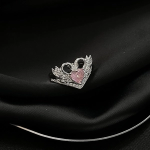 Detailansicht Silberring mit rosa Herzstein und Kristallflügeln auf schwarzer Seide