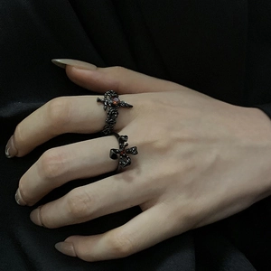 Détail de bagues style punk sombre avec épée en zircon rouge et motifs de croix