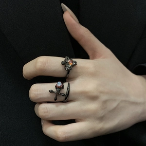 Vue détaillée de bagues gothiques noires avec croix et zircons rouges en cœur