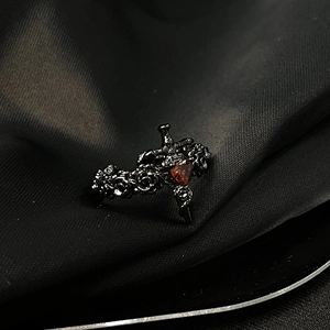 Détails de bague gothique noire avec cœur rouge et gravure de roses sur l'anneau