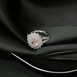 Detalle macro de un anillo de plata ajustable con circón rosa ovalado y halo de diamantes