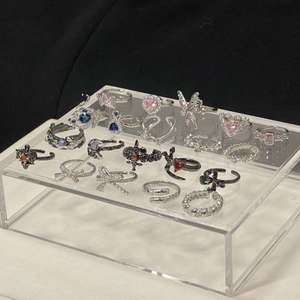 Makro-Display verschiedener Ringe mit rosa Schleifen und Schmetterlings-Designs auf Ständer