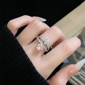 Nahaufnahme eines silbernen Überkreuz-Rings mit rosa Zirkonia im Kissenschliff und Birnenstein