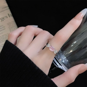 Detaillierte Makroansicht eines eleganten silbernen Schleifenrings mit rosa Zirkon