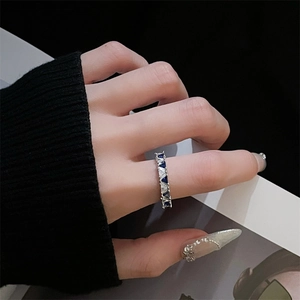 Dettaglio dell'anello in argento con gemme triangolari blu e bianche alternate