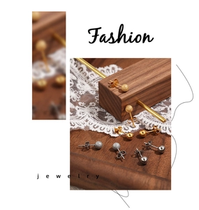 Détail de boucles d'oreilles boules en or et argent avec finitions mate et polie