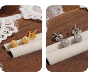 Vue détaillée des boucles d'oreilles boules mates dorées et argentées avec texture sablée