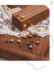 Vue détaillée de boucles d'oreilles boules en acier mat et poli sur du bois