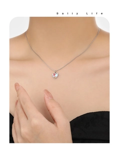 Détail d'un collier cœur argenté avec incrustation de pierre de lune sur un mannequin