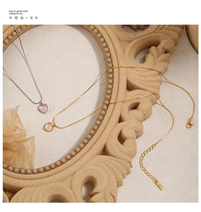 Détail de colliers cœur dorés et argentés avec pierres de lune sur fond vintage chic