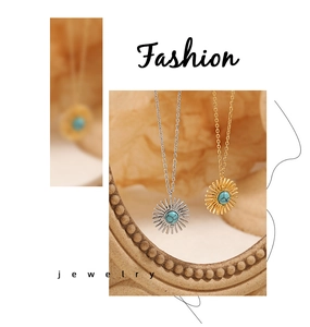 Detail of sunflower pendant necklace with turquoise center in gold and silver finish
