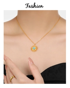 Close-up of bohemian sunburst necklace with turquoise stone and golden twisted ring