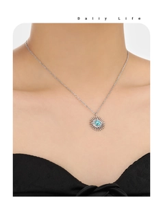 Detail of silver sunburst necklace with turquoise center on model for daily life