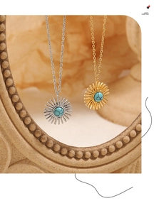 Macro detail of sunburst pendant necklaces in gold and silver with turquoise stones