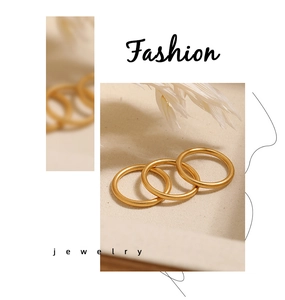 Detailweergave van drie minimalistische 2mm matgouden ringen op beige achtergrond