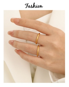 Detailopname van minimalistische 2mm matgouden titanium ringen gedragen door een model