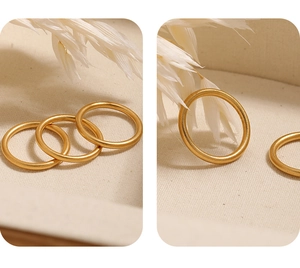 Detailopname van drie mat gouden 2mm gezandstraalde titanium stalen minimalistische ringen