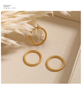 Detailweergave van drie minimalistische 2mm matgouden titanium ringen op een dienblad