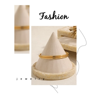 Detailed view of three minimalist gold stackable bracelets with shiny and matte finishes