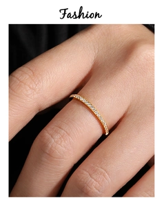 Nahaufnahme eines minimalistischen vergoldeten Rings mit funkelndem Zirkonia-Halbkreis