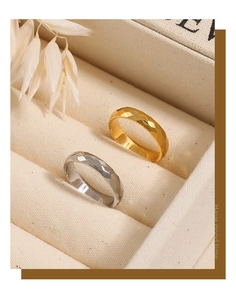 Detail von gold- und silberfarbenen Ringen mit Rautenmuster auf beigem Schmuckkästchen