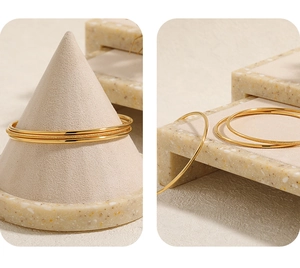Detail view of gold titanium steel bangle set featuring polished and matte sandblasted finishes