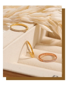 Makroaufnahme von Gold- und Roségoldringen mit Zirkonia auf beigem Display